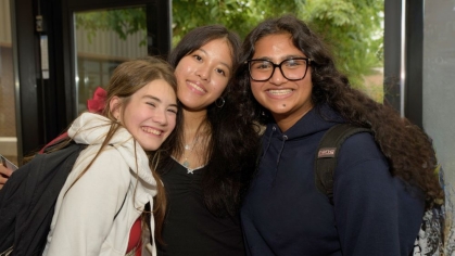 Three pre-college students smiling together