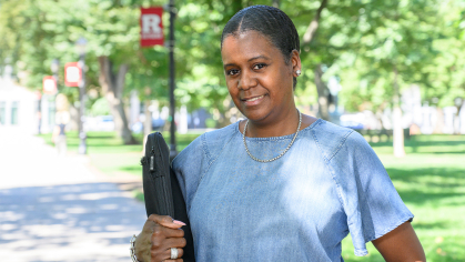 Student holding laptop smiling