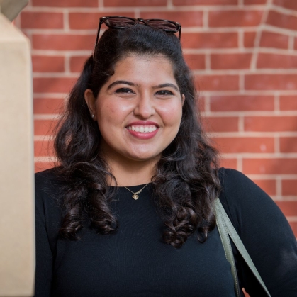 Student smiling in front of a building on Rutgers campus