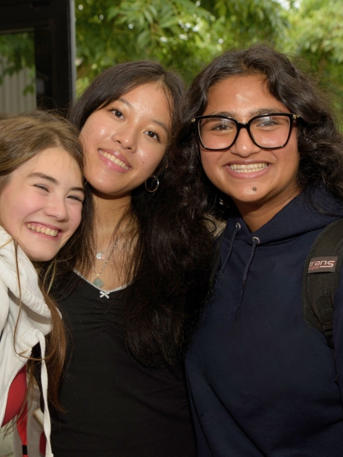 Three pre-college students smiling together