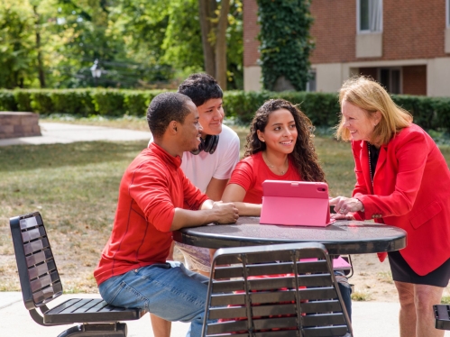 Rutgers professor teaching three students outside on campus
