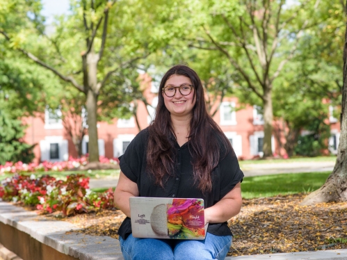 Student on their laptop outside at Rutgers campus on a summer day