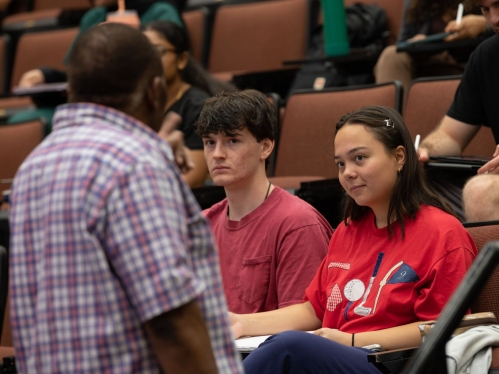 Summer students sitting in a lecture hall being taught by their professor